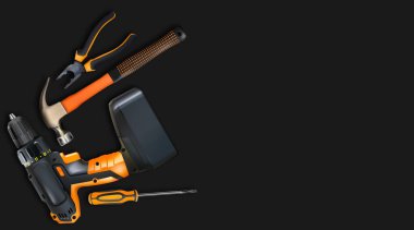 Turuncu aletler, siyah arka planda profesyonel gerçekçilik. Çekiç, kablosuz matkap, tornavida ve pense. Çilingir aleti, el metali işçilik günü için 3D kompozisyon. Kopyalama alanı.