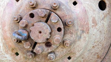 Paslı traktör tekerleği. Çürümüş tekerlek diski ve merkezi olan teknik bir arka plan. Eski traktör ya da ağır tarım makineleri. Sürgülü yuvarlak demir parçası..