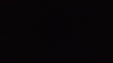 Gece hızla geçen trenin görüntüsü. Lokomotif ve vagonlar, her gece karanlıkta gidiyor. Bulanık sarı pencereler, karanlıkta tren geçerken ışıklar yanıp sönüyor..