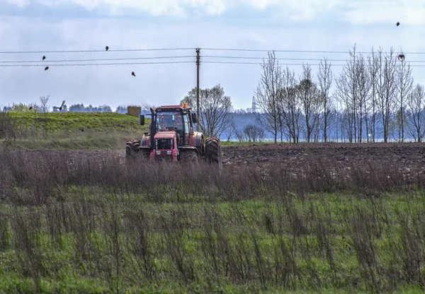 Trator arar um campo na primavera . — Fotografia de Stock