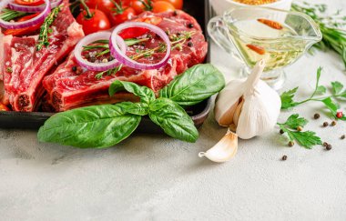 Gri beton arka planda baharatlı, otlu ve yağlı taze dana eti bifteği..