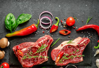 Pişirme malzemeleriyle marine edilmiş çiğ bifteklerin üst görüntüsü. Yukarıdan, boşluğu kopyala.