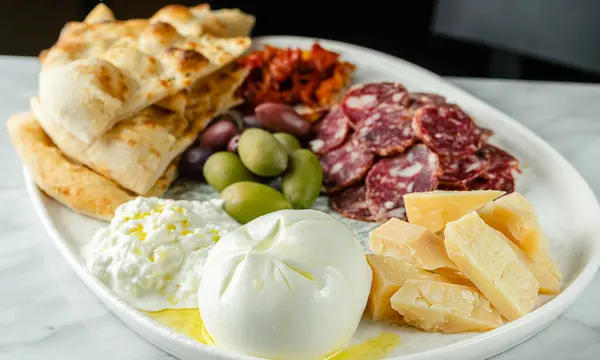 Italian snacks or antipasto platter with different cheese, meat and focaccia. Selective focus. — Stock Photo, Image