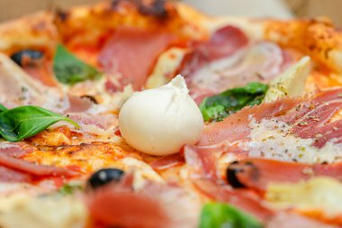 Domates soslu taze pişmiş pizza, prosciutto ve mozzarella. İtalyan mutfağı. Seçici odak