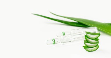 Aloe vera beyaz arka planda ampul ve dilimlenmiş yapraklar halinde özüt eder. Alternatif tıp.