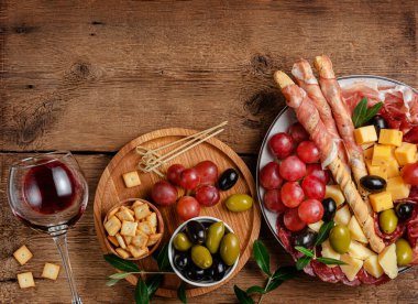 Tahta arka planda İtalyan antipasto tabağı. Üst görünüm, alanı kopyala