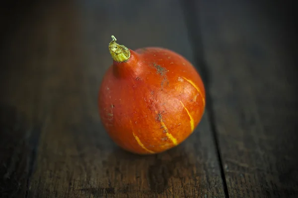 Red kuri squash on a dark wooden table