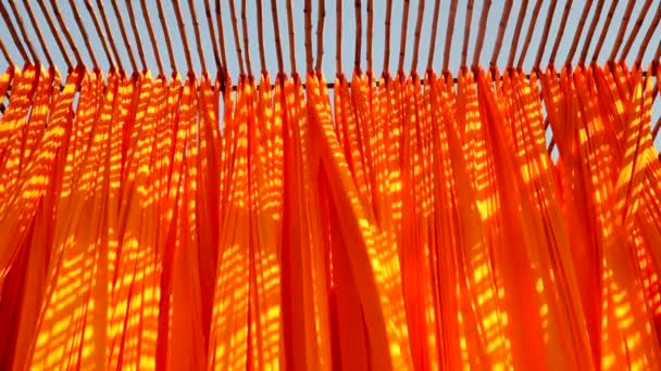 Färgat tyg hängande från bambu stolpar — Stockvideo