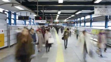 Shibuya İstasyonu'nda hareket eden bir geçitte commuters