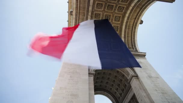 Bandeira francesa que voa sob o Arco do Triunfo — Vídeo de Stock