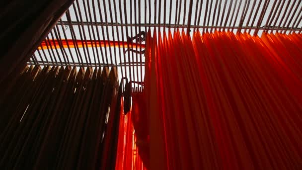 Пофарбована тканина, що звисає з бамбукових стовпів — стокове відео