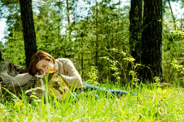 Eenzaam meisje genieten van een kopje groene thee in het bos — Stockfoto