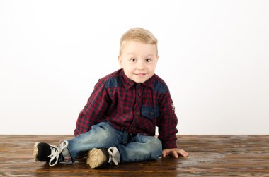 Mutlu küçük çocuk stüdyoda oynuyor.