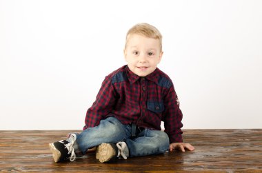 Mutlu küçük çocuk stüdyoda oynuyor.