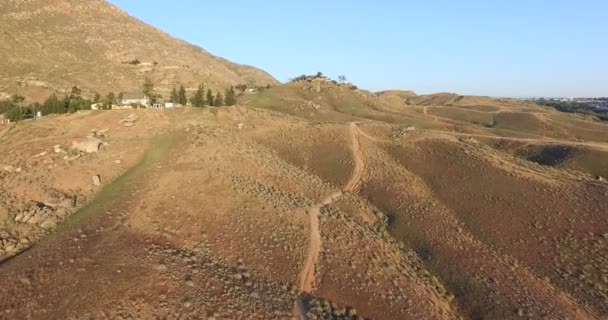 Camino en colinas con casas circundantes — Vídeos de Stock