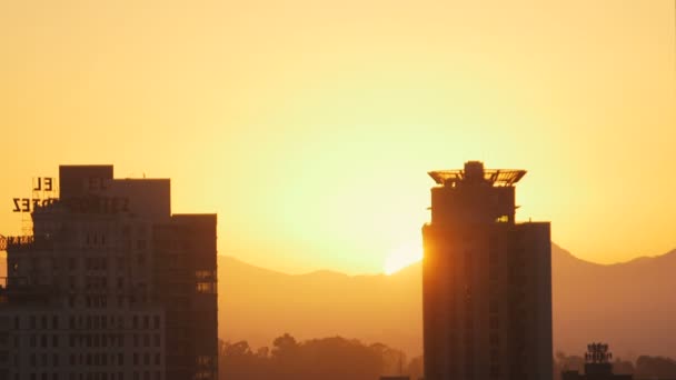Puesta de sol en la ciudad entre edificios — Vídeos de Stock