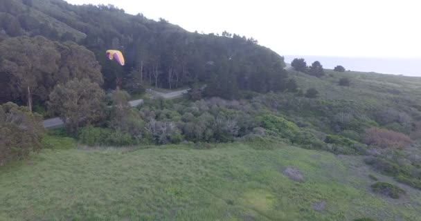 Homme parapente au-dessus des forêts et des collines 