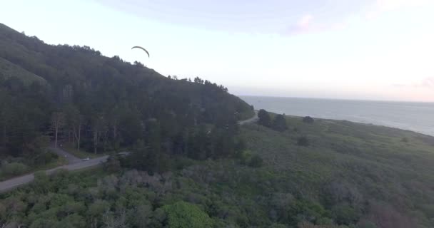 男人滑翔伞以上森林和丘陵 — 图库视频影像
