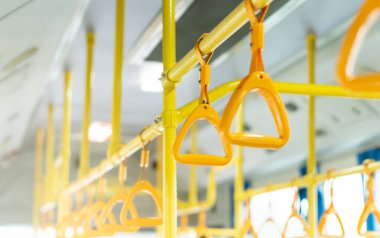 Tavandaki sarı otobüs kulpu ayakta duran yolcu için, toplu taşıma treni tırabzanı iç tarafta.