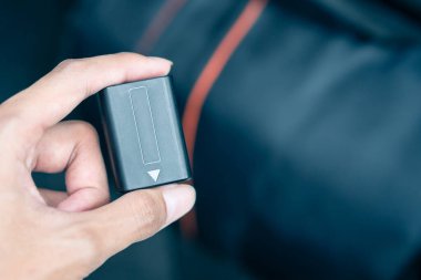 Arka planda kamera çantasıyla el ele tutuşan Lityum Bataryası, acil durum seyahatinden önce dijital kamera aksesuarları yedekleme kontrolü