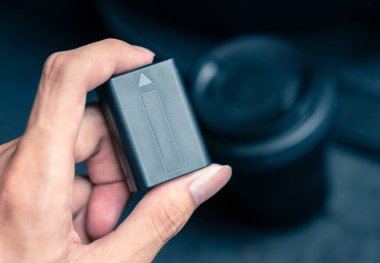 Arka planda kamera lensi olan el ele tutuşma Lityum Bataryası, Acil durumlar için dijital kamera aksesuarları yedekleme denetimi unutuldu
