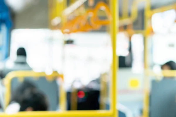 people in the public transport bus, blurred interior background