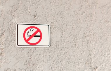 Grunge Stone desen duvarında sigara sembolü olan beyaz bir tabela yasak bölge dumanı.