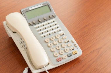 Masadaki eski ofis telefonu iş iletişimi için, çok dilli retro içsel 1990 model telefon arkaplanı kopya alanı ile