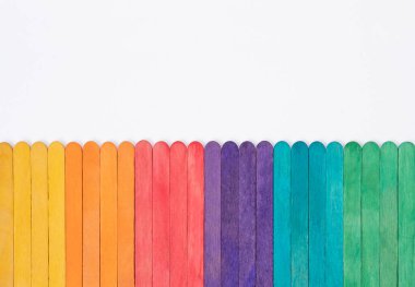 Renkli gökkuşağı ahşap buzlu çubuklar beyaz kağıt üzerinde fotokopi alanı, soyut renk çubukları çocuk sanatları çalışmaları için çerçeve, çocuklar okul konseptine geri dönüyor.