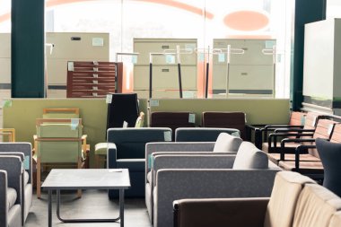 Modern stil sandalyeler ikinci el mobilya deposunda satılıyor, yaşam tarzı oturma odası tasarımı ise galeride.