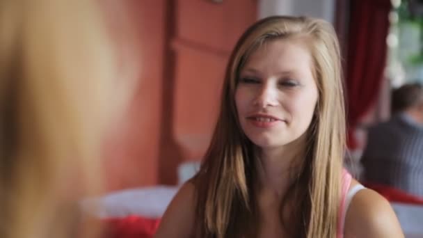 Две улыбающиеся девушки разговаривают — стоковое видео