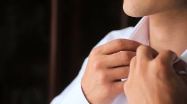 Kadar bir pencerenin önünde gömleğinin düğmelerini adam