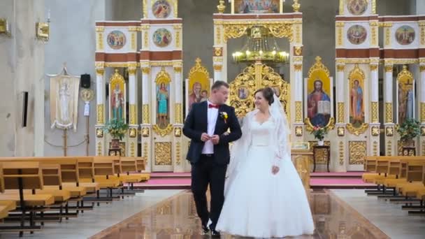 A noiva eo noivo sair da igreja — Vídeo de Stock
