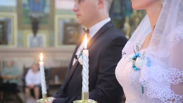 Молодая пара в церкви проводит свадебные свечи — стоковое видео