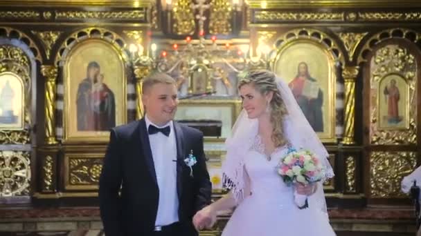 A noiva eo noivo sair da igreja — Vídeo de Stock