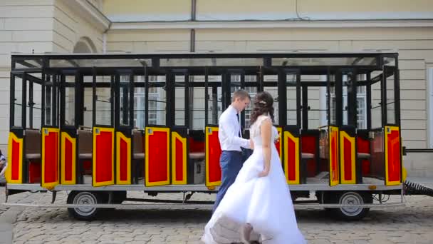 Ungt par promenader i stad nära spårvagn — Stockvideo