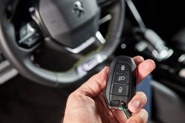 Vinnitsa, Ukrayna - 19 Ekim 2020. Peugeot 2008 - galeride yeni model araba sunumu - direksiyonun arka planına karşı anahtarlar sahibinin elinde