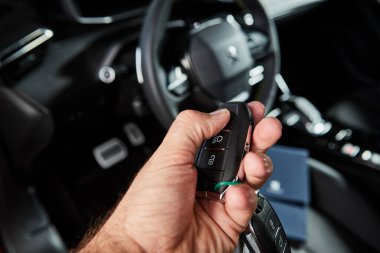 Vinnitsa, Ukrayna - 19 Ekim 2020. Peugeot 2008 - galeride yeni model araba sunumu - direksiyonun arka planına karşı anahtarlar sahibinin elinde