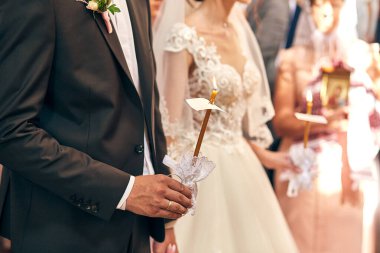 Yeni evliler kilisedeki bir törende alyanslarını takıyorlar.