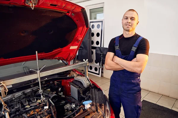 Repairing a car engine in auto-service center. Auto mechanic working in the garage