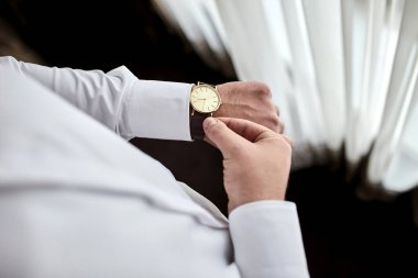 İş adamı kol saatini kontrol ediyor, saati eline alıyor, damat düğün töreninden önce hazırlanıyor. Erkekler Moda