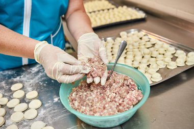 Şefin elleri arka planda el yapımı ravioli ve un serpiştirilmiş khinkali ile yapılan hamur tatlısı pişiriyor. Lezzetli ev yemekleri..