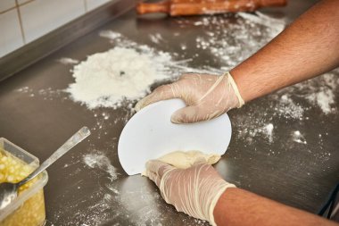 Kadın şef pasta pişirmek için hamuru oklavayla sarar.