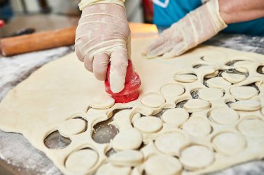 Şefin elleri arka planda el yapımı ravioli ve un serpiştirilmiş khinkali ile yapılan hamur tatlısı pişiriyor. Lezzetli ev yemekleri..