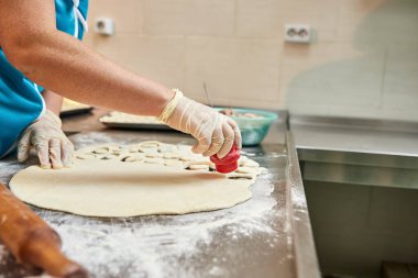 Şefin elleri arka planda el yapımı ravioli ve un serpiştirilmiş khinkali ile yapılan hamur tatlısı pişiriyor. Lezzetli ev yemekleri..