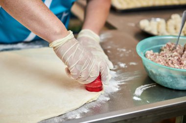 Şefin elleri arka planda el yapımı ravioli ve un serpiştirilmiş khinkali ile yapılan hamur tatlısı pişiriyor. Lezzetli ev yemekleri..