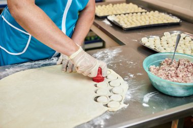 Şefin elleri arka planda el yapımı ravioli ve un serpiştirilmiş khinkali ile yapılan hamur tatlısı pişiriyor. Lezzetli ev yemekleri..