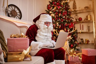 Noel Baba evinde oturuyor ve dizüstü bilgisayarında Noel 'le e-posta okuyor. Şöminenin yanında bir dilek listesi ve hediyeli bir ağaç istiyor. Yeni yıl ve Mutlu Noeller, Mutlu Noeller konsepti