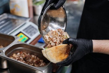 Şef ızgara et ve taze sebzeli Pita ekmeği ile shawarma sandviçi hazırlıyor. Yüksek kalite fotoğraf
