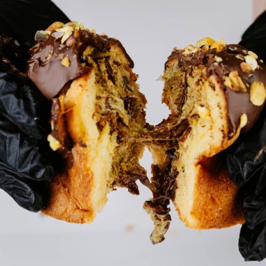 Noel panettonunu yapışkan çikolata dolgulu, şenlikli tatlı ile yırtan eller. Yüksek kalite fotoğraf